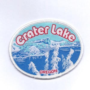 May include: White, blue, and red embroidered patch with the text "Crater Lake Oregon" and a scenic image of a lake and mountains.