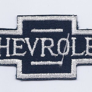May include: A navy blue embroidered patch with a white outline and the word "CHEVROLET" in white lettering.