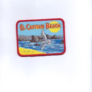 May include: A red, yellow, and blue embroidered patch with the text "El Capitan Beach" and a seagull flying over a beach scene.