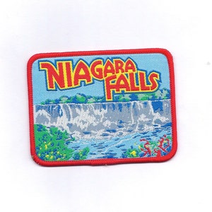 May include: Red, white, and blue embroidered patch with the words "NIAGARA FALLS" in red and white lettering. The patch features a depiction of Niagara Falls with green trees and blue water.