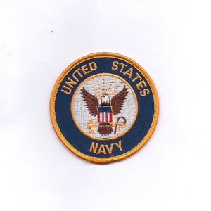 May include: A blue and gold embroidered patch with the words "United States Navy" and a white eagle with a red, white, and blue shield.