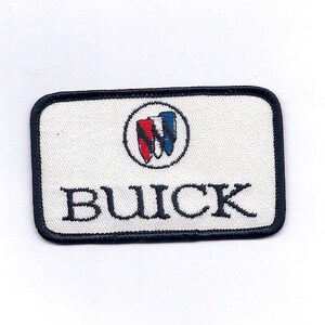 May include: White embroidered patch with a black border. The patch features a red, white, and blue logo with the word "BUICK" in black lettering.