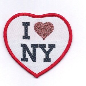 May include: Red heart-shaped patch with a white background and the text "I love NY" in black. The heart has a smaller red heart with glitter inside.