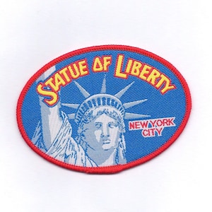 May include: A blue and red oval-shaped patch with the words "Statue of Liberty" in yellow lettering and "New York City" in red lettering. The patch features a white embroidered image of the Statue of Liberty.