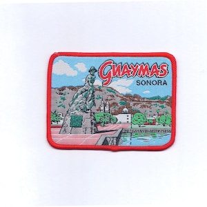 May include: A blue and red embroidered patch with a picture of a statue and the text "Guaymas Sonora".