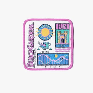 May include: A pink and white embroidered patch featuring the text "Busch Gardens Williamsburg, VA." and images of a sun, a roller coaster, and a castle. The text "Good Times", "Fun Times", and "All The Time" are also included.