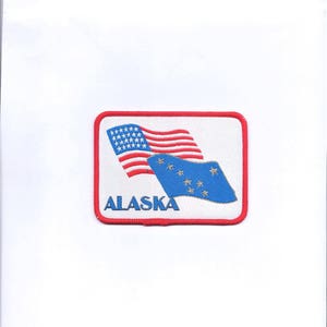 May include: An embroidered patch featuring the American and Alaskan flags, with the word "ALASKA" in red lettering.