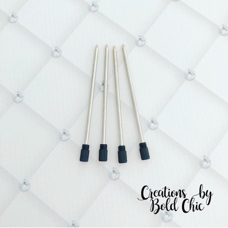 May include: Four silver pen refills with black rubber tips. The refills are arranged vertically on a white background.