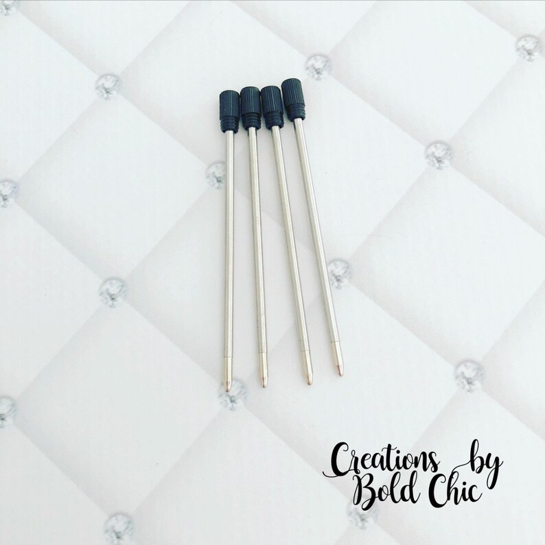 May include: Four silver pen refills with black plastic tops.