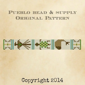 May include: A beaded pattern featuring a green, brown, and white design. The pattern includes a stylised bird, a turtle, and a crescent moon. The text "Pueblo Bead & Supply Original Pattern Copyright 2014" is at the top and bottom of the image.