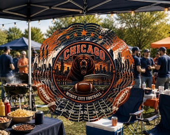 May include: A circular metal wind spinner featuring a graphic of a roaring bear, the Chicago skyline, a football stadium, and a football. The text reads CHICAGO and WINDY CITY FOOTBALL. The design includes orange and blue colours with star accents.