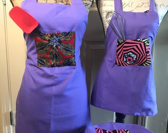 IMANI (Faith) APRON SET. Mommy and Me or Grandma and Me. Purple reverses to light pink. Aduld 26-1/2". Child 23-1/2". Handmade in Kenya.