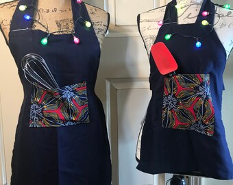 IMANI (Faith) APRON SET.  Mommy/Grandma and Me.  Navy blue with red print pocket.  Adult 25 inches.  Child 17-18 inches.  Handmade in Kenya.