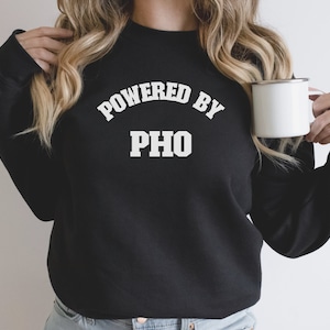 May include: Black sweatshirt with white text that reads "Powered by Pho".