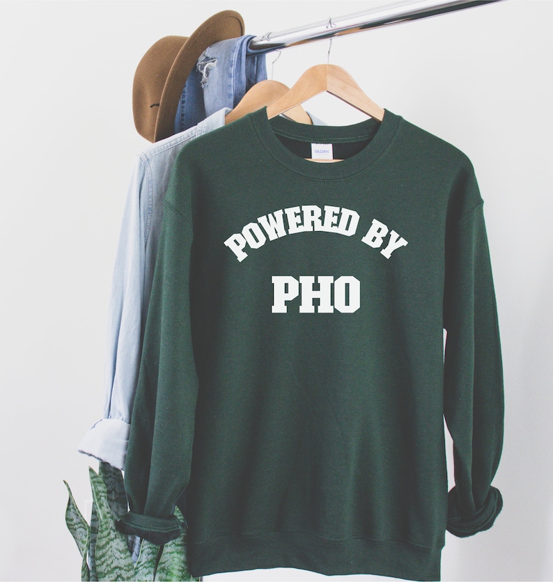 May include: A dark green sweatshirt with white text that reads "Powered by Pho".