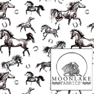 May include: White fabric with a repeating pattern of black and gray watercolor-style horses in various poses, with horseshoes scattered throughout. The Moonlake Fabrics logo is in the lower right corner.