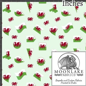 May include: A green fabric with a repeating pattern of red Welsh dragons in various shapes and sizes. The fabric is printed with the text "MOONLAKE FABRICS" and "Bespoke and Custom Fabrics Printed to Order".