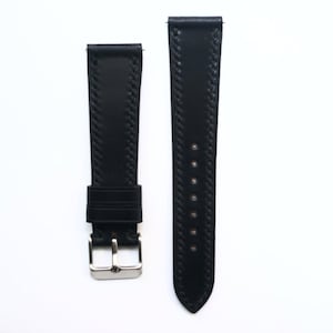 May include: Two black leather watch straps with a silver buckle. The straps have a stitched design.
