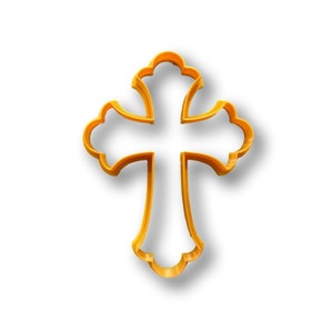 May include: A gold-colored metal cookie cutter in the shape of a cross with ornate details.