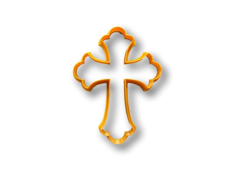 May include: A gold-colored metal cookie cutter in the shape of a cross with ornate details.