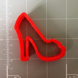 May include: Red plastic cookie cutter shaped like a high-heeled shoe.