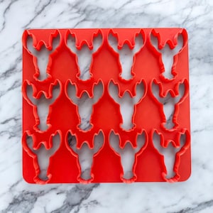 Puede incluir: Conjunto de 12 cortadores de galletas de plástico rojo en forma de langosta.
