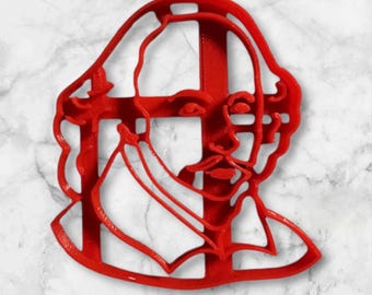 May include: Red plastic cookie cutter shaped like a profile of William Shakespeare. The cutter is designed with a detailed outline of his face, hair, and collar.