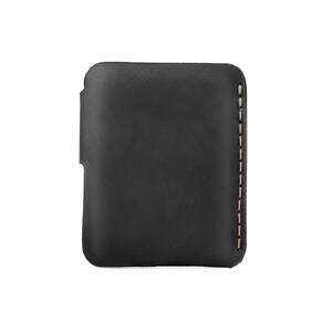 May include: A black leather phone case with a stitched edge. The case is rectangular with rounded corners and a cutout on one side. The stitching is a light tan color, providing contrast against the dark leather.