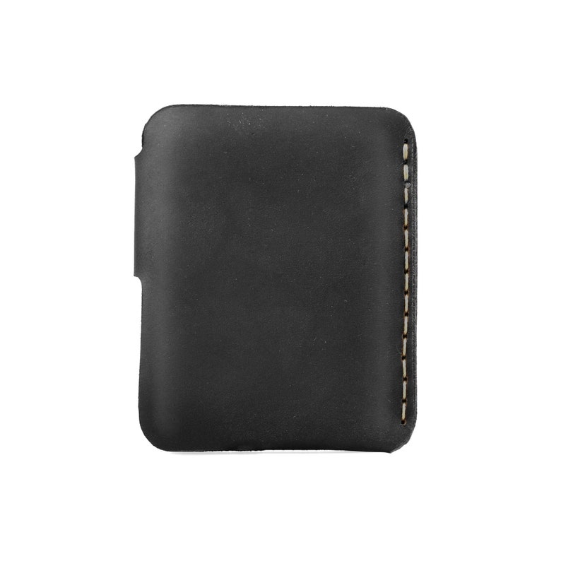 May include: A black leather phone case with a stitched edge. The case is rectangular with rounded corners and a cutout on one side. The stitching is a light tan color, providing contrast against the dark leather.