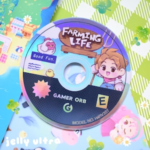 May include: A holographic CD with the title "Farming Life" and a cartoon farmer illustration. The disc also features a chicken, chick, and the text "Good Fun." The disc is labeled "Gamer Orb" and has a rating of "E".