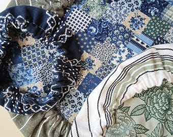 May include: A collection of three round fabric bowl covers with elasticized edges. One cover features a blue and white patchwork floral pattern, another has a dark olive green and white striped design, and the third displays a green floral print.