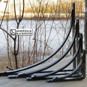 Size selection of our shelf brackets displayed in a true Adirondack setting with a rustic pine post in background. Sizes 4", 6", 8" and 10".