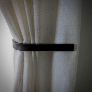 Gentle curtain tie backs like those from Adirondack Blacksmith (pictured)are easy on window treatments with soft gathering of curtains and without any obstructions to cause scrunching, creasing or puckers in the material. Conceals wall mount.