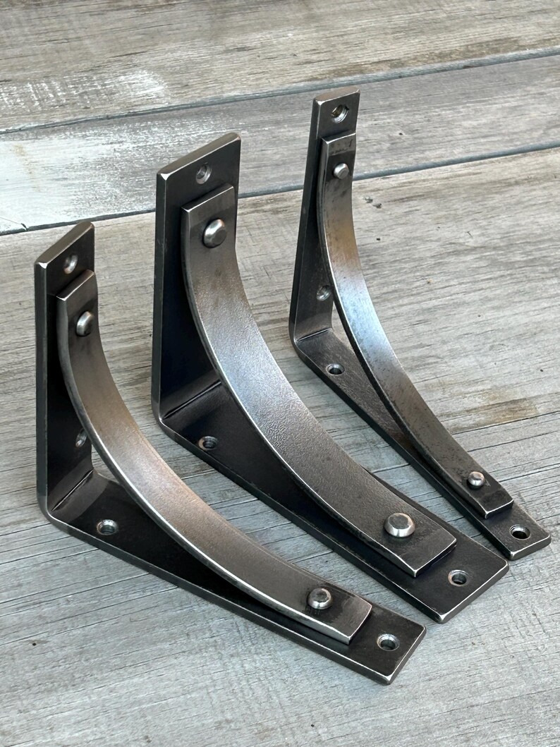 Our Station line of bracket...from left to right, Station Extra, Station Grande and Station all in 6" size and clearcoat over a paint ready finish. Displayed on weathered pine slab table.