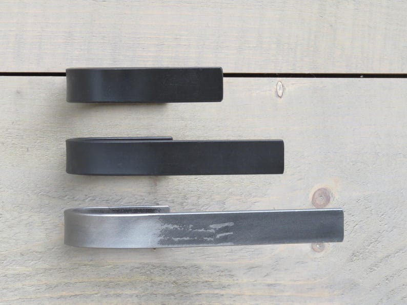 May include: Three metal door handles in different finishes. The top handle is black, the middle handle is black, and the bottom handle is a brushed nickel finish.