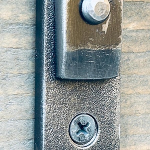 Close-up of arc end-bevel and hammer-set rivet with hand-hammered faceting to rivet head.