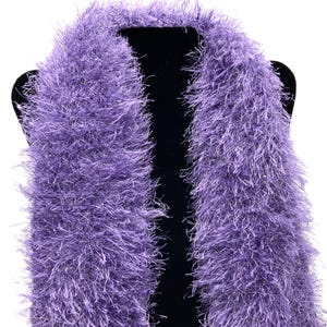 May include: A purple fuzzy scarf with a soft, fluffy texture. The scarf is displayed on a black mannequin.