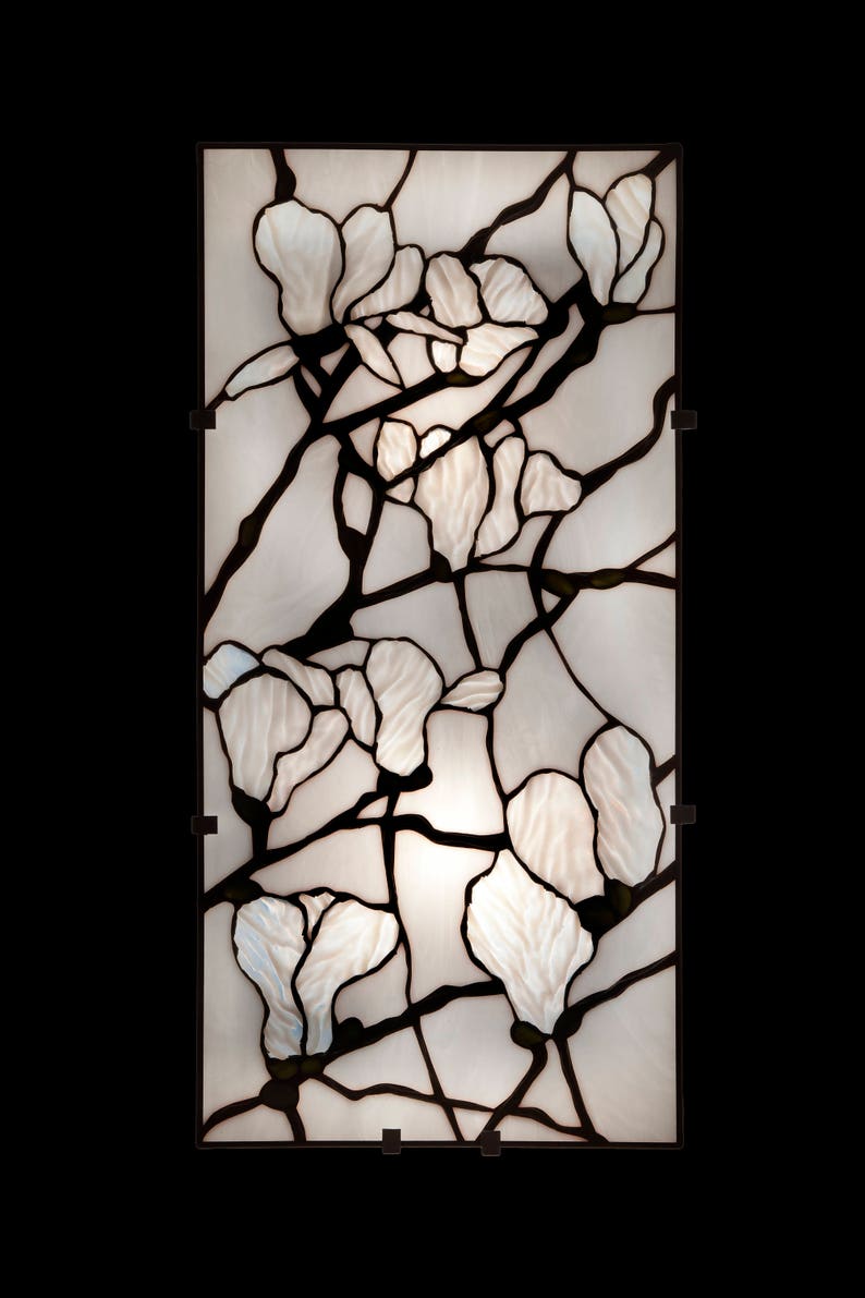 May include: A stained glass panel with a design of white magnolia blossoms and black branches.