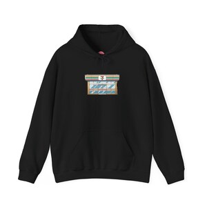 Op de afbeelding: Zwart hoodie met een afbeelding van een 7-Eleven winkelgevel op de borst.