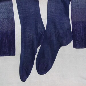 May include: A pair of dark blue sheer stockings with a seam up the back of the leg.