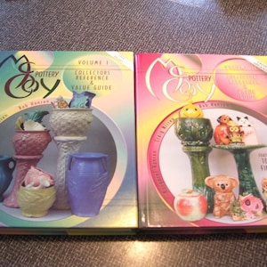 May include: Two volumes of a book series titled "Mc Coy Pottery" with colorful illustrations of pottery pieces on the covers. Volume 1 is a collectors reference and value guide. Volume 2 features the top 100 findables.