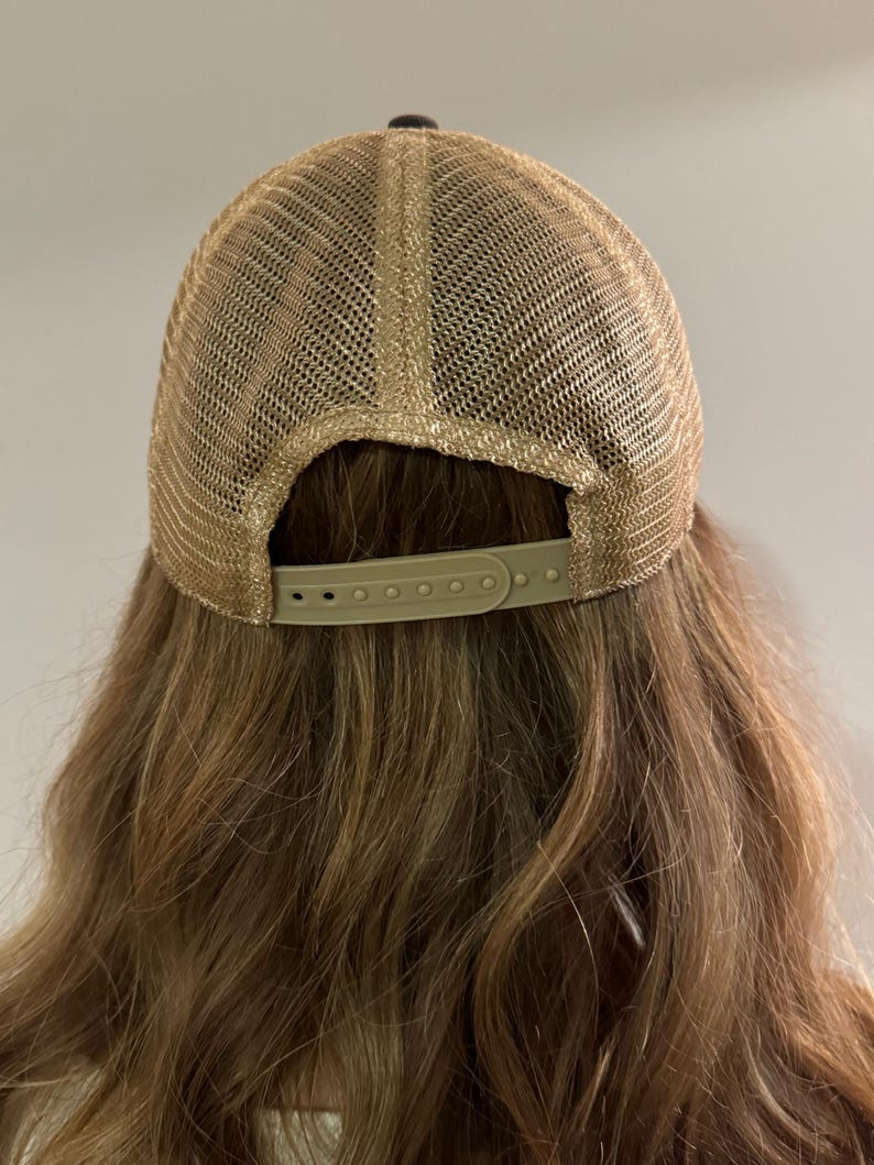 May include: A brown mesh baseball cap with a black brim and a brown adjustable strap in the back.