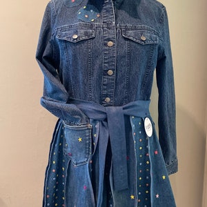 May include: A denim dress with a blue belt and colorful polka dots and stars embroidered on the skirt.