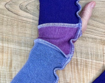Arm wrist warmers made from preloved wool sweaters in shades of purple.