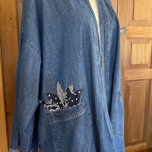 Chambray denim open front jacket with appliquéd flower