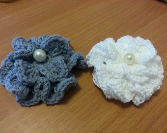Puede incluir: Dos pinzas para el pelo de flores de ganchillo, una en gris con una perla blanca y otra en blanco con una perla blanca.