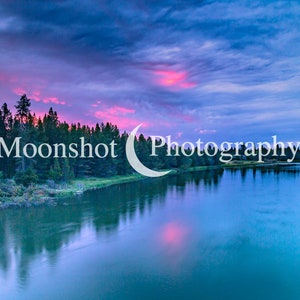 May include: A scenic landscape photograph of a river winding through a forest at sunset. The sky is a vibrant mix of pink, purple, and blue with clouds. The river reflects the colors of the sky. The text "Moonshot Photography" is superimposed on the image.