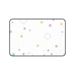 May include: A rectangular white mousepad with a black border. The surface features a grid pattern with scattered pastel stars in yellow, pink, blue, and green, along with cloud shapes. Small gray dots are also present.