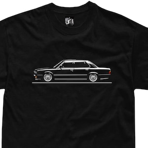 May include: Black t-shirt featuring a white outline of a black car on the front.