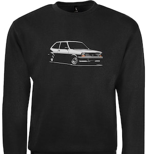 Może przedstawiać: Czarna bluza z białym obrysem klasycznego Forda Fiesty.